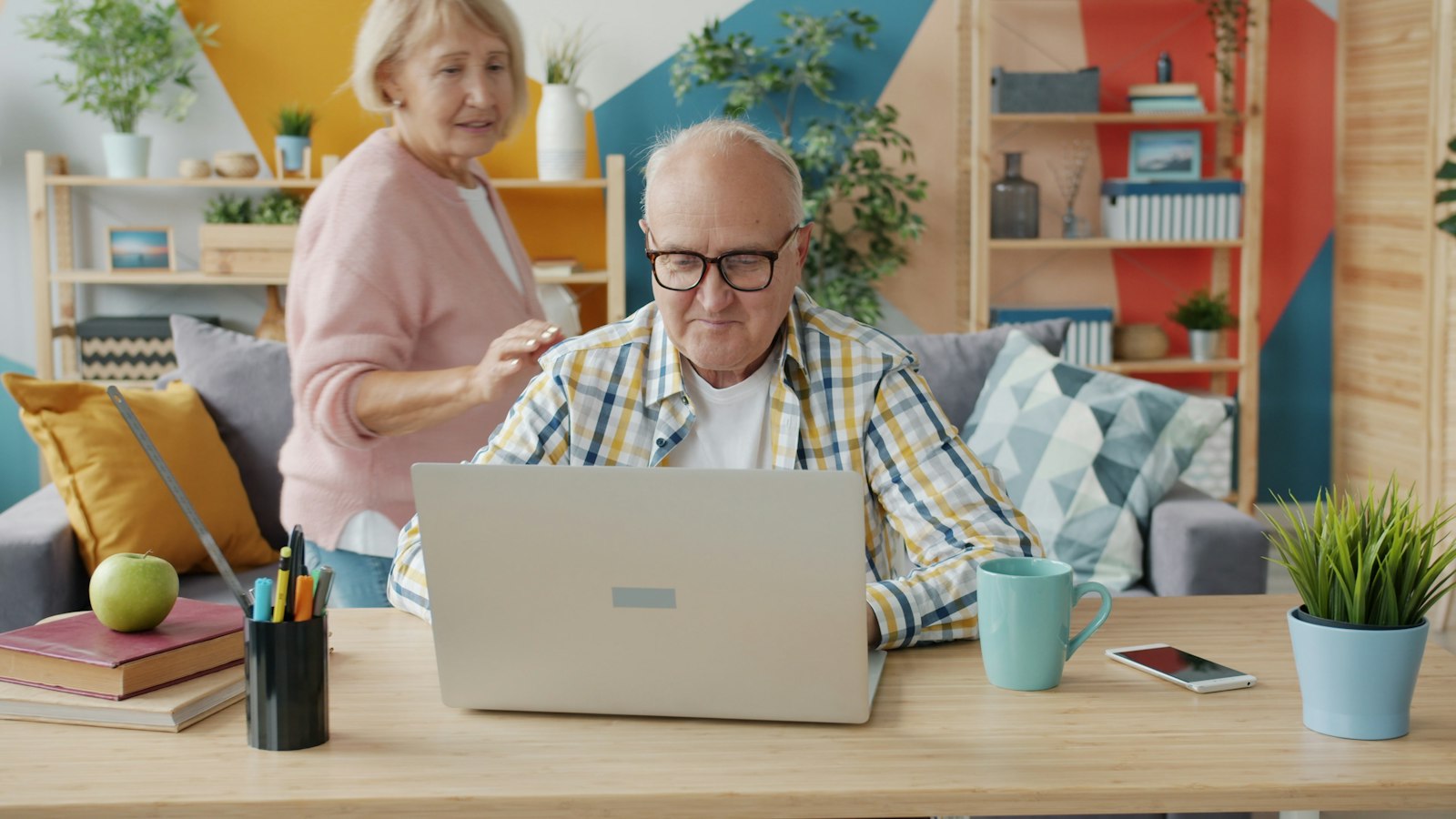 Older couple using a laptop together in their living room