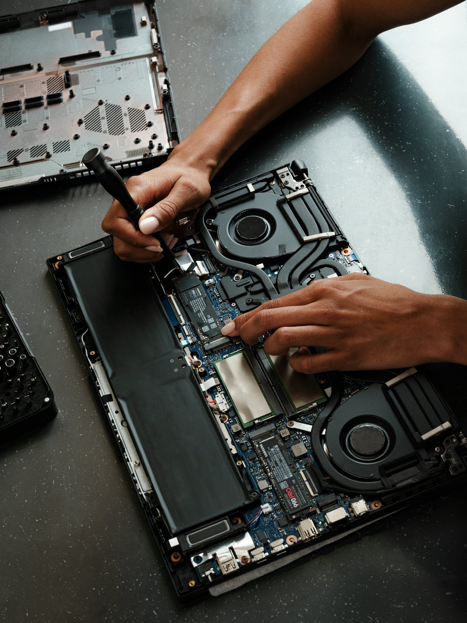 Technician upgrading components inside a laptop